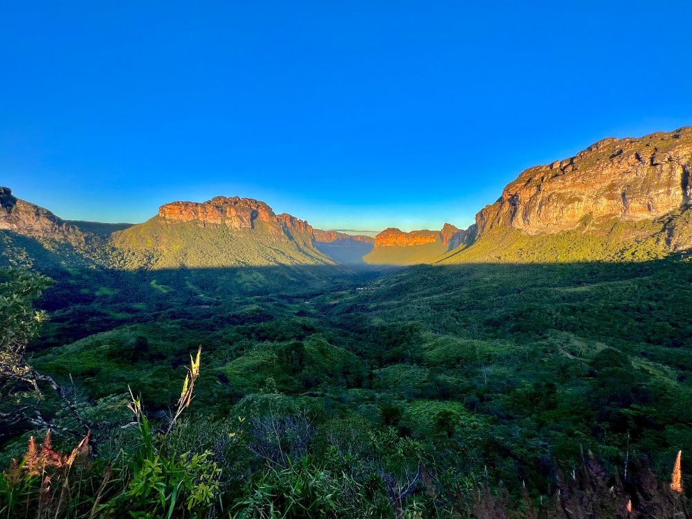 Panoramic view of the vast valley and green mountains illuminated by the sun under a blue sky in Chapada Diamantina National Park. Panoramic view of the vast valley and green mountains illuminated by the sun under a blue sky in Chapada Diamantina National Park.
