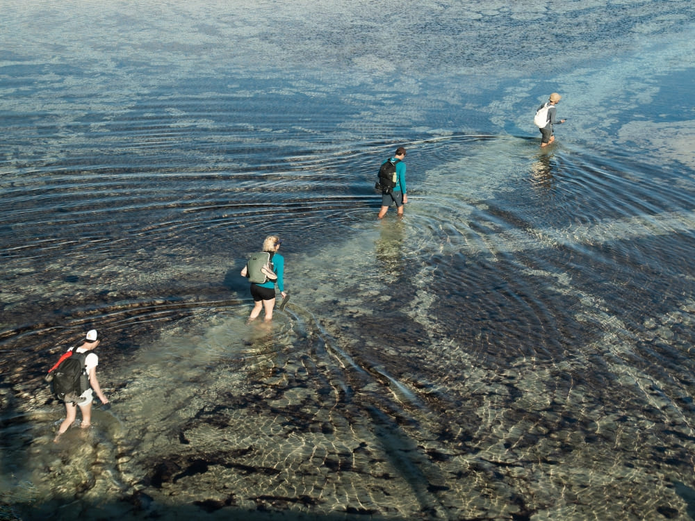 A guided group of travelers hiking through shallow water in the endless sand dunes on a Lençóis Maranhenses tour. A guided group of travelers hiking through shallow water in the endless sand dunes on a Lençóis Maranhenses tour.