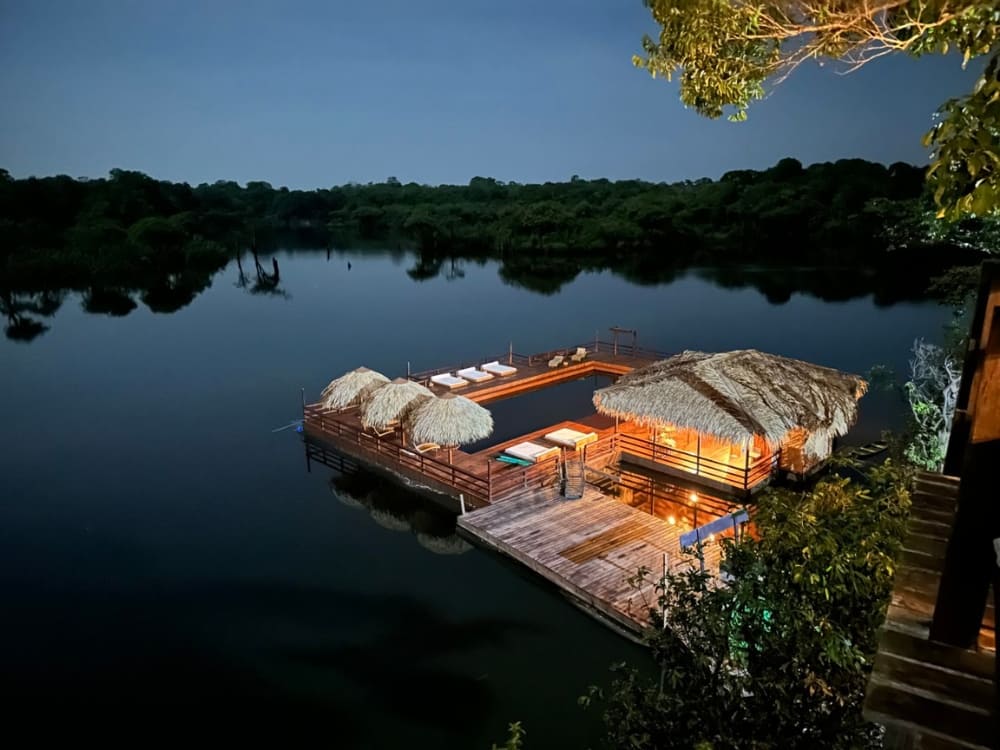 A floating deck and pool illuminated at night at Juma Amazon Lodge in the Amazon rainforest.