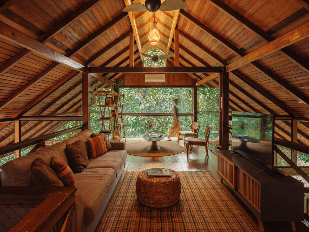 A cozy, rustic interior of a wooden bungalow at an Amazon ecolodge featuring a comfortable living area and a view of the forest. A cozy, rustic interior of a wooden bungalow at an Amazon ecolodge featuring a comfortable living area and a view of the forest.