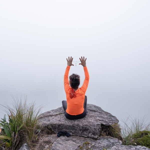 Um viajante meditando na neblina no planalto do cume do Monte Roraima
