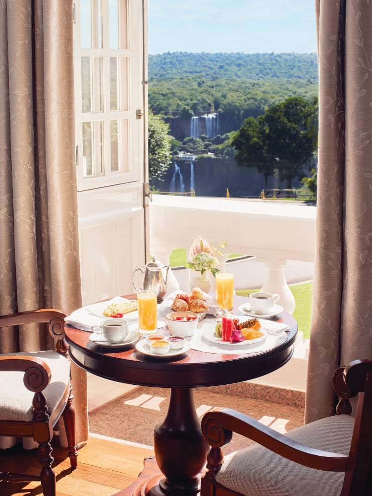 Café da manhã servido junto à porta aberta com vista para as Cataratas do Iguaçu, no Hotel das Cataratas, no Brasil.