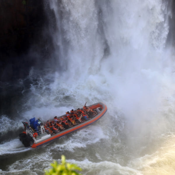 Bote do Macuco Safari levando visitantes até a neblina de água no pé das Cataratas do Iguaçu, no Brasil.