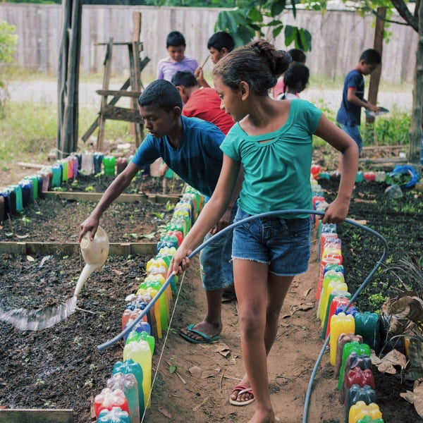 Children tending a recycled-bottle garden in a Novo Airão Amazon community