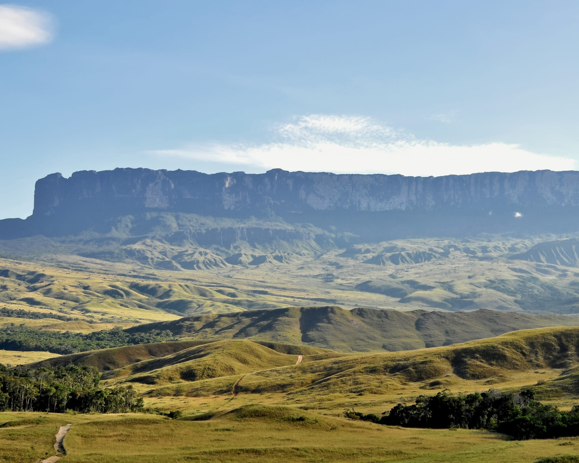 O tepui de topo plano do Monte Roraima erguendo-se sobre a savana verde da Gran Sabana, na Venezuela