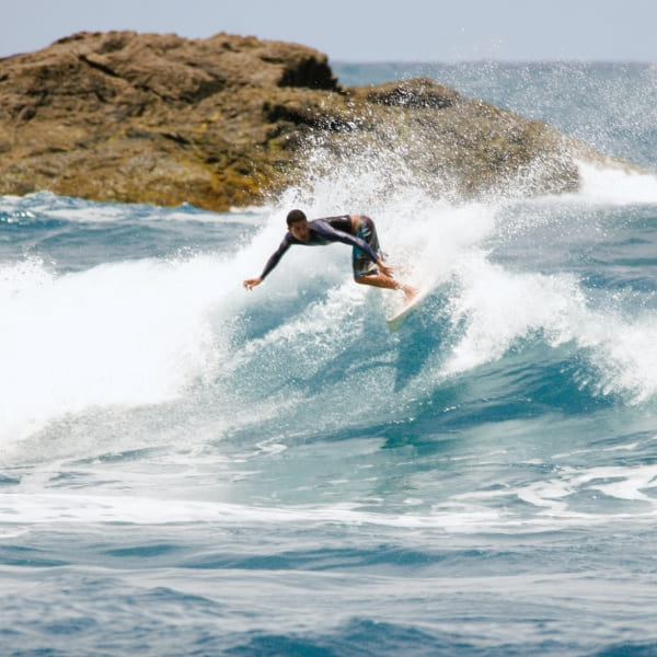 Surfista deslizando em uma onda no litoral de Itacaré, Bahia, Brasil.
