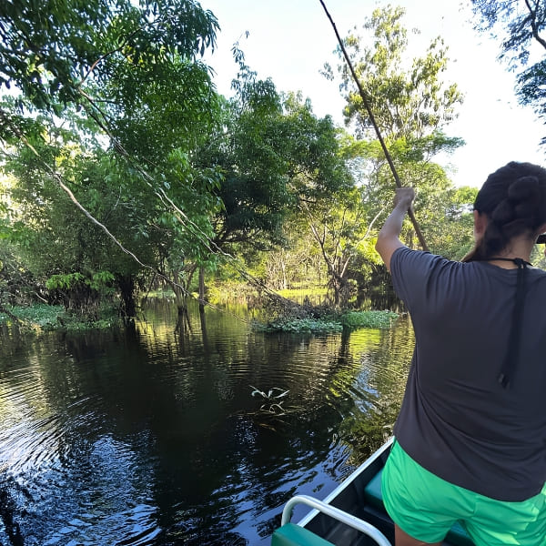Viajante pescando piranha de vara em uma canoa na floresta alagada da Amazônia